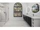 Bathroom featuring a large window, dual sinks, sleek fixtures, and a glass-enclosed shower at 4444 Robin Hood Trl W, Sarasota, FL 34232
