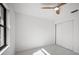 Bright bedroom features a ceiling fan, window, and closet doors at 4444 Robin Hood Trl W, Sarasota, FL 34232