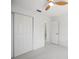 Clean, airy bedroom featuring a ceiling fan, closet doors and neutral decor with plenty of natural light at 4444 Robin Hood Trl W, Sarasota, FL 34232