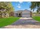 Beautiful single-story home showcasing a lush lawn, brick accents, and a two-car garage at 4444 Robin Hood Trl W, Sarasota, FL 34232