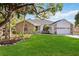 Beautiful home boasts lush landscaping, a two-car garage, and brick and siding exterior elements at 4444 Robin Hood Trl W, Sarasota, FL 34232