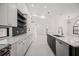 Stylish kitchen with white cabinets, quartz countertops, a black backsplash, and stainless steel appliances at 4444 Robin Hood Trl W, Sarasota, FL 34232
