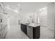 Bright, open kitchen featuring an island with black cabinets and stainless steel appliances at 4444 Robin Hood Trl W, Sarasota, FL 34232