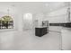 Open-concept kitchen and living room featuring white cabinets, an island, and a large window at 4444 Robin Hood Trl W, Sarasota, FL 34232