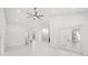 Spacious living room with high ceilings and a modern ceiling fan, illuminated by recessed lighting at 4444 Robin Hood Trl W, Sarasota, FL 34232