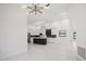 Expansive living room featuring sleek lighting fixtures, leading into modern kitchen with island at 4444 Robin Hood Trl W, Sarasota, FL 34232
