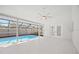 Inviting screened-in pool area featuring a light ceiling fan and neutral color palette at 4444 Robin Hood Trl W, Sarasota, FL 34232