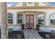 Inviting front door with decorative glass, flanked by large windows and lush greenery at 4624 Blue Marlin Dr, Bradenton, FL 34208