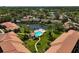 Aerial view highlighting a condo community with a pool area, pond views, and lush landscaping at 5201 Lake Village Dr # 14, Sarasota, FL 34235
