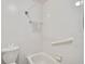 Full bathroom featuring a tub with white tile surround, grab bar, and commode at 5201 Lake Village Dr # 14, Sarasota, FL 34235