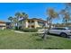 Two-story condo building, lush greenery, with sidewalk and parked white SUV at 5201 Lake Village Dr # 14, Sarasota, FL 34235