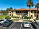 Exterior view of condos featuring tile roofs and well-maintained landscaping plus guest parking at 5201 Lake Village Dr # 14, Sarasota, FL 34235