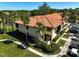 Exterior view of condo with tile roof, palm trees, lush grass and parking spots for residents and guests at 5201 Lake Village Dr # 14, Sarasota, FL 34235