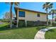 Exterior of condo building with grass lawn, mature shrubs, and walkway at 5201 Lake Village Dr # 14, Sarasota, FL 34235