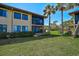 Outdoor view of the condo building with a screened-in lanai and view of the lawn at 5201 Lake Village Dr # 14, Sarasota, FL 34235