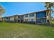 Charming two-story condo building with screened balconies and manicured landscaping on a sunny day at 5201 Lake Village Dr # 14, Sarasota, FL 34235