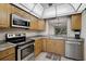 Well-lit kitchen with stainless appliances, wood cabinets, and a pass-through to the dining area at 5201 Lake Village Dr # 14, Sarasota, FL 34235
