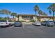 Condo parking lot with guest parking spaces near a building with lush landscaping and palm trees at 5201 Lake Village Dr # 14, Sarasota, FL 34235