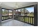 Enclosed porch with tile flooring and expansive views of well-maintained lawn and tropical foliage at 5201 Lake Village Dr # 14, Sarasota, FL 34235