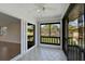 Enclosed sunroom featuring tile flooring, a ceiling fan, and sliding glass doors with a view of the outdoors at 5201 Lake Village Dr # 14, Sarasota, FL 34235