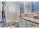 Bright bathroom featuring tiled walls, granite vanity, and updated fixtures at 600 Sutton Pl # 104, Longboat Key, FL 34228