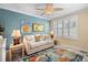 Cozy bedroom with comfortable seating, tropical artwork, and natural light at 600 Sutton Pl # 104, Longboat Key, FL 34228