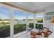 Bright sunroom offers tranquil waterfront views from the rattan seating area at 600 Sutton Pl # 104, Longboat Key, FL 34228