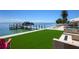 A lush backyard has a private boat dock, a luxurious in-ground pool and patio, and outdoor kitchen at 606 Crestwood Ln, Holmes Beach, FL 34217