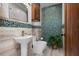 Bathroom featuring a pedestal sink, modern toilet, and green river rock accents at 606 Crestwood Ln, Holmes Beach, FL 34217