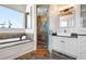Bathroom with soaking tub, walk-in shower, double vanity, wood ceiling and tile floor at 606 Crestwood Ln, Holmes Beach, FL 34217