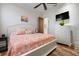Bedroom with warm-toned quilt, flat screen television, and beautiful hardwood floors at 606 Crestwood Ln, Holmes Beach, FL 34217