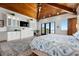 Primary bedroom with vaulted wood ceilings, dresser with TV, and balcony access at 606 Crestwood Ln, Holmes Beach, FL 34217