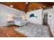 Relaxing bedroom with hardwood floors, ceiling beams, ensuite bar, walk-in closet and coastal decor at 606 Crestwood Ln, Holmes Beach, FL 34217