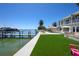 Backyard with lush landscaping, dock and boat lift, outdoor kitchen, and in-ground pool at 606 Crestwood Ln, Holmes Beach, FL 34217