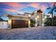 Attractive two-story home featuring a large garage, brick driveway, and manicured landscaping at 606 Crestwood Ln, Holmes Beach, FL 34217