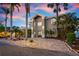 Elegant two-story home with lush landscaping and a paver driveway, showcasing sophisticated curb appeal at 606 Crestwood Ln, Holmes Beach, FL 34217
