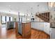 Open concept kitchen with stainless steel appliances, island, and staircase with wine rack at 606 Crestwood Ln, Holmes Beach, FL 34217