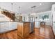 Kitchen island features white cabinetry, countertop space, stainless steel dishwasher, and hardwood floors at 606 Crestwood Ln, Holmes Beach, FL 34217