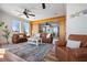 Bright living room with ceiling fan, wooden beam, and seamless transition to the connecting bedroom at 606 Crestwood Ln, Holmes Beach, FL 34217