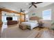 Bright main bedroom boasts a wicker bed frame, ceiling fan, and sliding barn door to the connecting living area at 606 Crestwood Ln, Holmes Beach, FL 34217