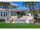 Inviting outdoor kitchen area with seating around a fire pit and lush landscaping at 606 Crestwood Ln, Holmes Beach, FL 34217