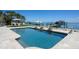 Beautiful backyard with an inviting pool and lounge area overlooking the waterfront and private boat dock at 606 Crestwood Ln, Holmes Beach, FL 34217