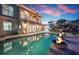 A luxurious pool with fire bowls at twilight, set against a beautifully landscaped backyard at 606 Crestwood Ln, Holmes Beach, FL 34217