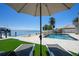 Waterfront pool with lounging chairs, dock, and ocean views create a relaxing outdoor oasis at 606 Crestwood Ln, Holmes Beach, FL 34217