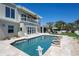 Backyard pool with patio, dolphin sculpture, and outdoor kitchen at 606 Crestwood Ln, Holmes Beach, FL 34217