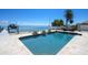 A refreshing swimming pool and patio are surrounded by lush landscaping with waterfront views at 606 Crestwood Ln, Holmes Beach, FL 34217