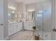Elegant bathroom with double sinks, marble countertops, and a glass-enclosed shower, offering a spa-like experience at 6172 Lungo Lago Dr, Sarasota, FL 34241