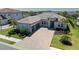 Stunning single Gathering home with a paver driveway, tile roof, 2 car garage, and manicured lawn at 6172 Lungo Lago Dr, Sarasota, FL 34241