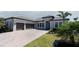 Beautiful exterior elevation featuring a tile roof, three-car garage, and green grass at 6172 Lungo Lago Dr, Sarasota, FL 34241