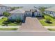 Attractive single-story home with a tile roof, two-car garage, paver driveway, and tropical landscaping at 6172 Lungo Lago Dr, Sarasota, FL 34241